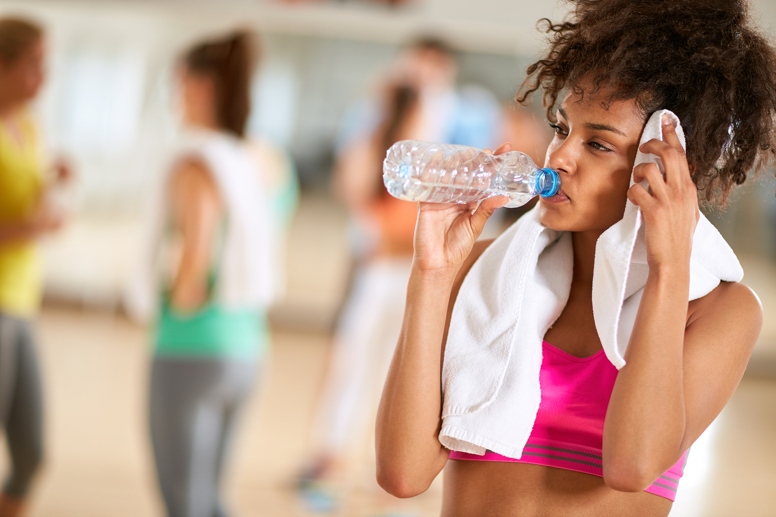 Woman drinking water to stay hydrated while exercising.