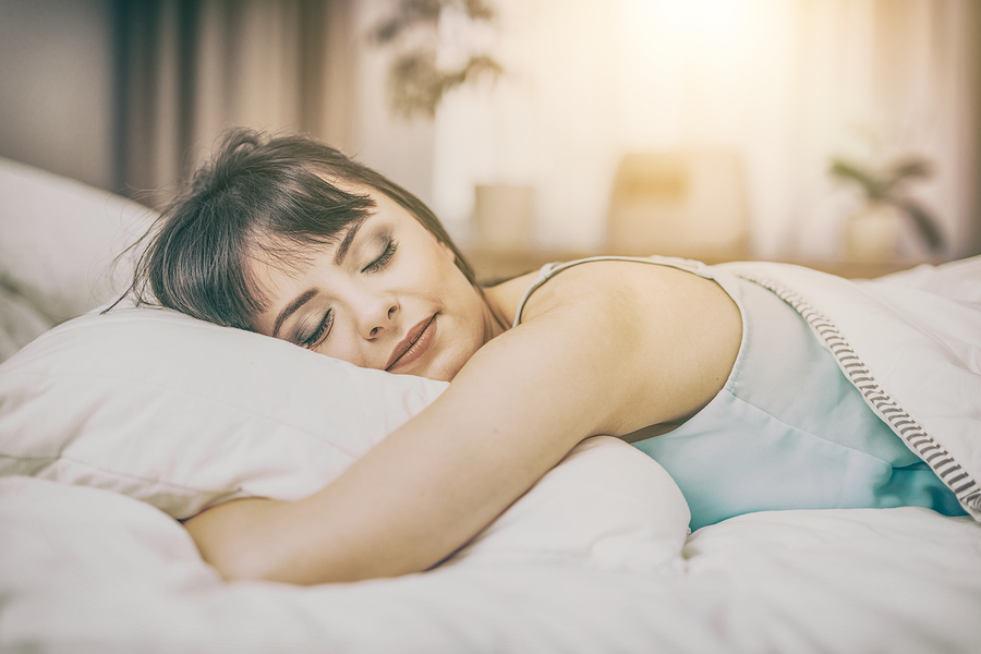 Beautiful young woman sleeping on a bed in the bedroom. A peaceful sleep makes you happy.